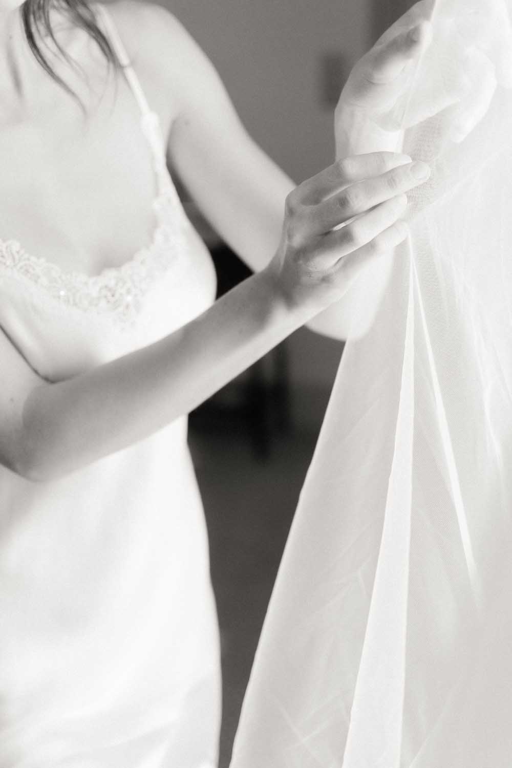 la mariée touche sa robe de mariage